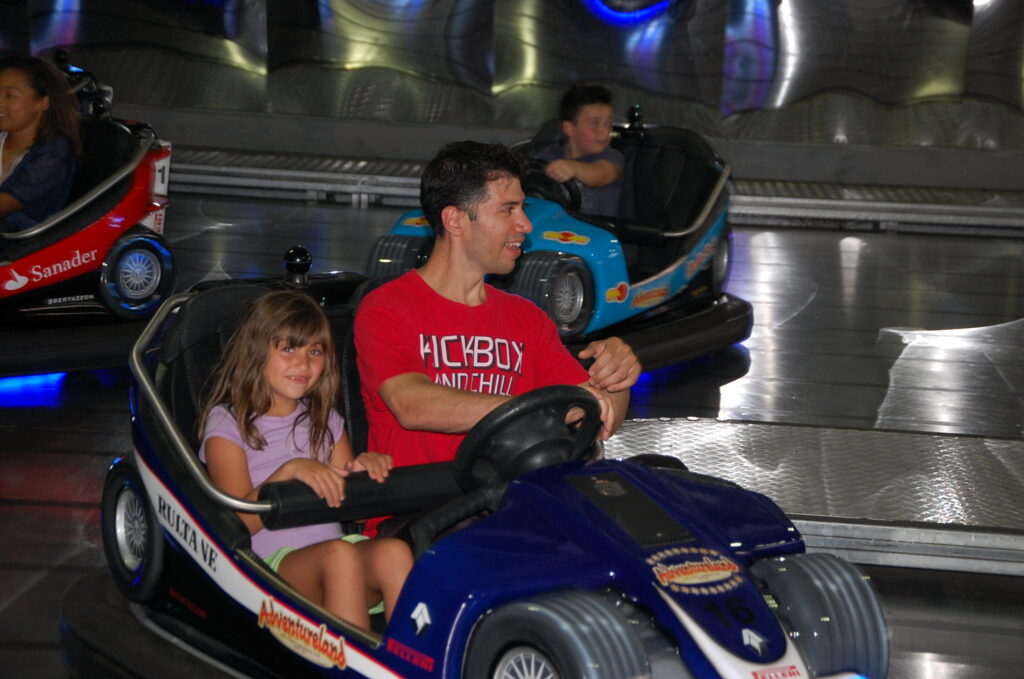 Dad and girl driving a bumper car at Adventureland